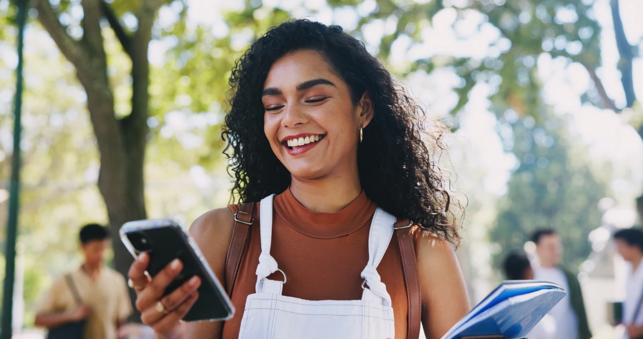 Woman looking at her phone while walking outside